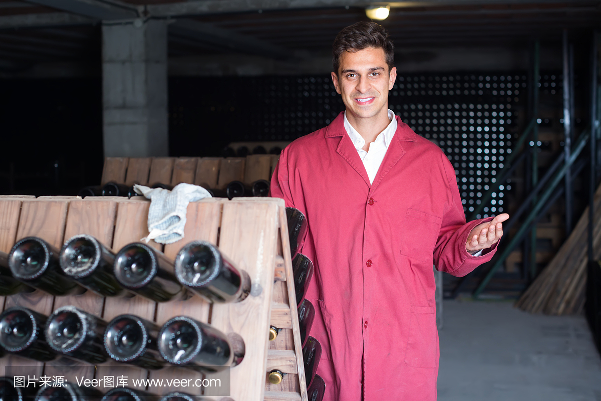 微笑的男人穿著制服工作與瓶子儲存架